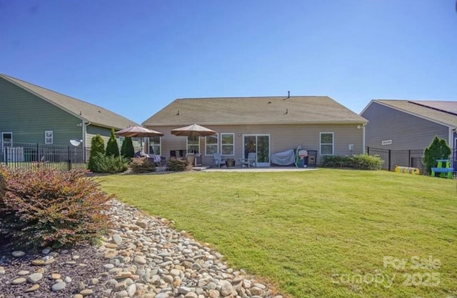 rear view of property with a yard, a patio, and fence