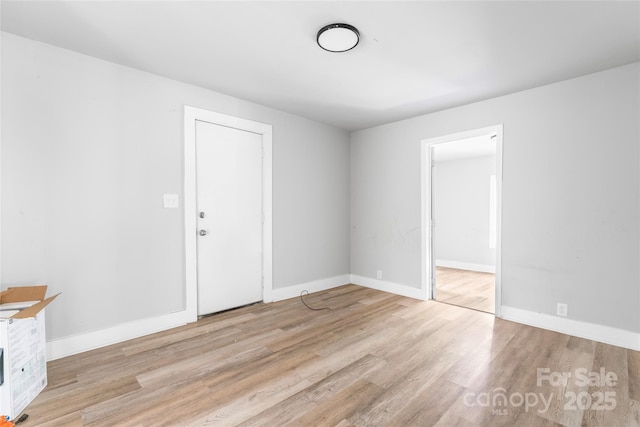 empty room featuring baseboards and wood finished floors