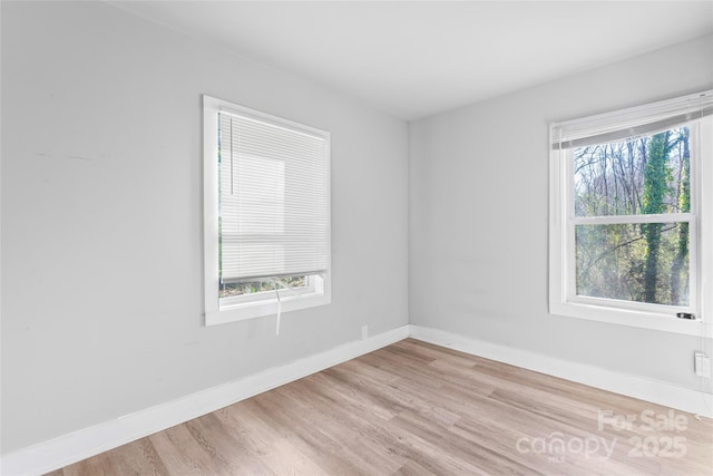 unfurnished room featuring baseboards and light wood finished floors