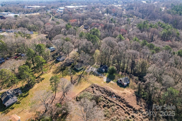 birds eye view of property featuring a view of trees