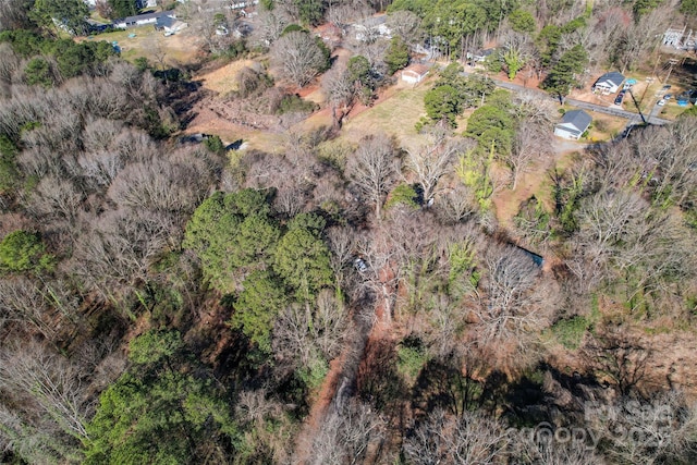 birds eye view of property featuring a forest view