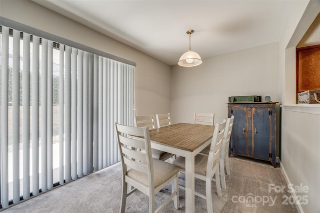 dining space with baseboards and carpet