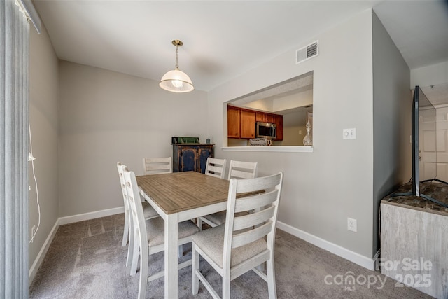 carpeted dining space with visible vents and baseboards