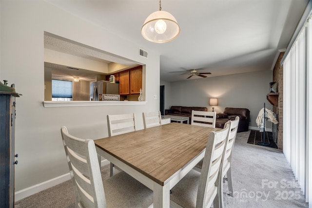 dining room featuring baseboards, light colored carpet, visible vents, and ceiling fan