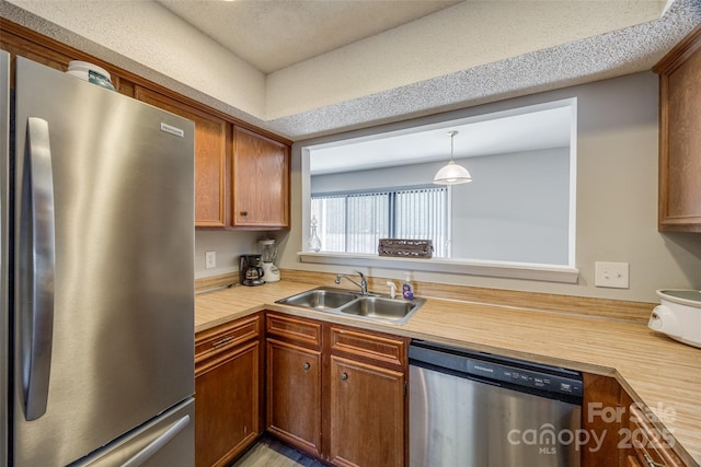 kitchen with brown cabinetry, appliances with stainless steel finishes, and a sink