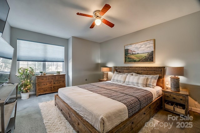 carpeted bedroom featuring baseboards and a ceiling fan