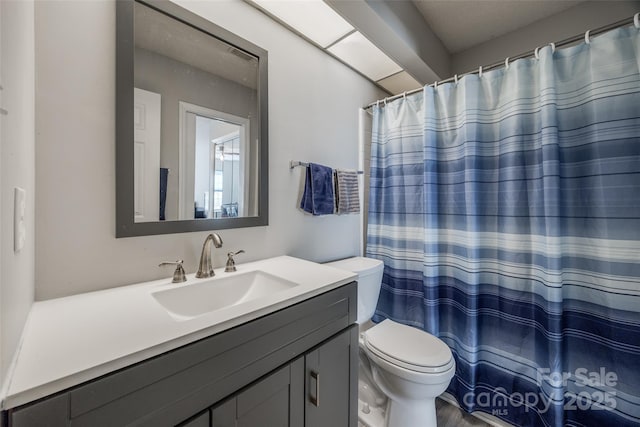 bathroom with vanity, curtained shower, and toilet