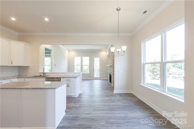 kitchen with a peninsula, white cabinets, and crown molding