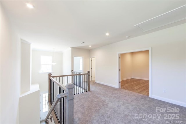 hall with baseboards, attic access, carpet floors, an upstairs landing, and recessed lighting