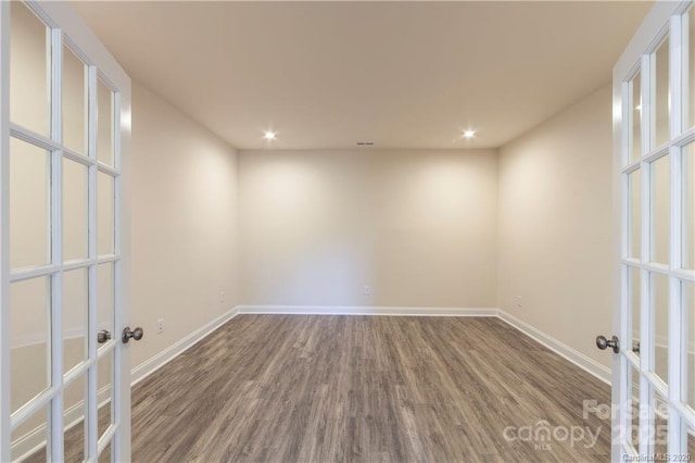 spare room featuring recessed lighting, french doors, baseboards, and wood finished floors