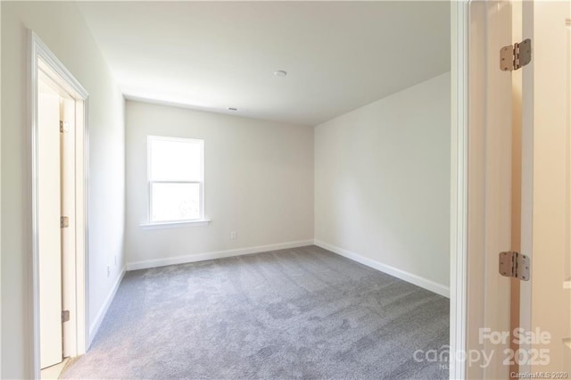 unfurnished room with baseboards and carpet