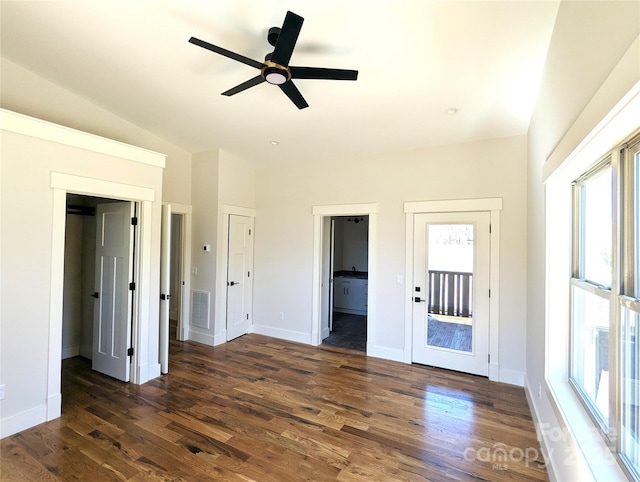 unfurnished bedroom featuring multiple windows, dark wood-style floors, and visible vents