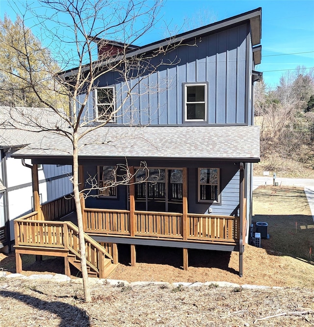 view of front of home featuring board and batten siding, covered porch, central AC, and roof with shingles