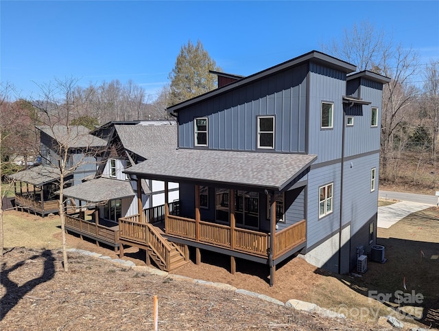 back of house featuring a shingled roof and a deck