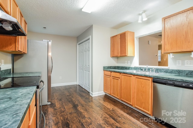 kitchen with dark wood-style flooring, a sink, appliances with stainless steel finishes, a textured ceiling, and exhaust hood