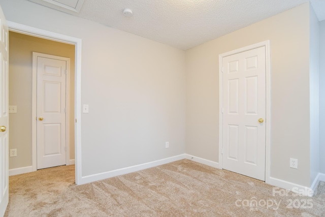 unfurnished room featuring baseboards, carpet floors, and a textured ceiling