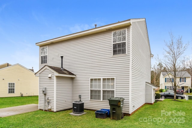 back of property with a yard and central AC unit