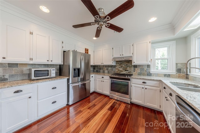 kitchen featuring a sink, a ceiling fan, white cabinetry, appliances with stainless steel finishes, and under cabinet range hood