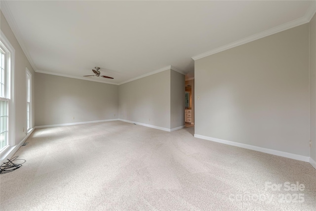spare room featuring light carpet, crown molding, baseboards, and ceiling fan
