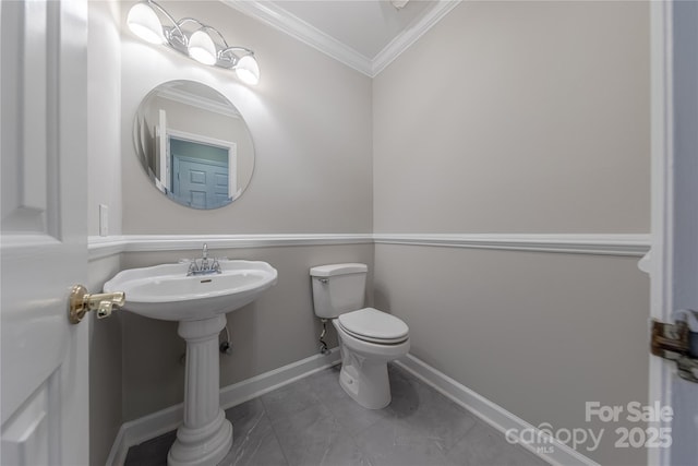 bathroom featuring toilet, crown molding, baseboards, and tile patterned floors
