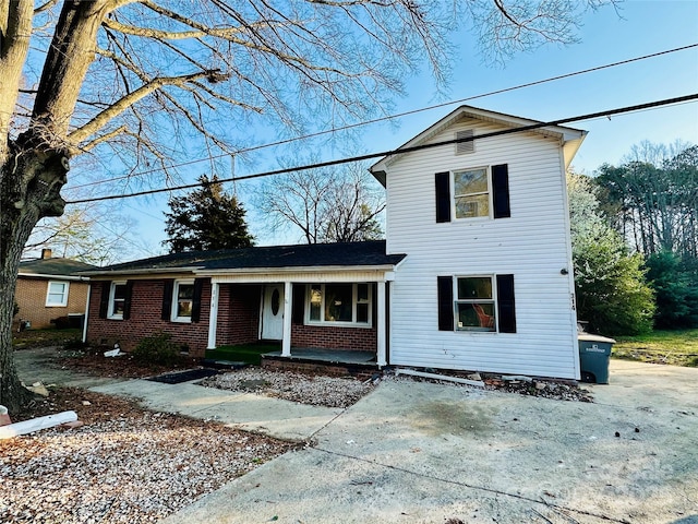 traditional-style house featuring brick siding and covered porch