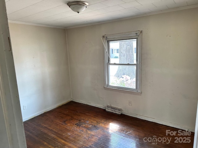 spare room with hardwood / wood-style floors, crown molding, visible vents, and a wealth of natural light