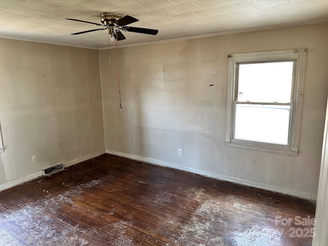 empty room with visible vents, ornamental molding, a ceiling fan, hardwood / wood-style floors, and baseboards