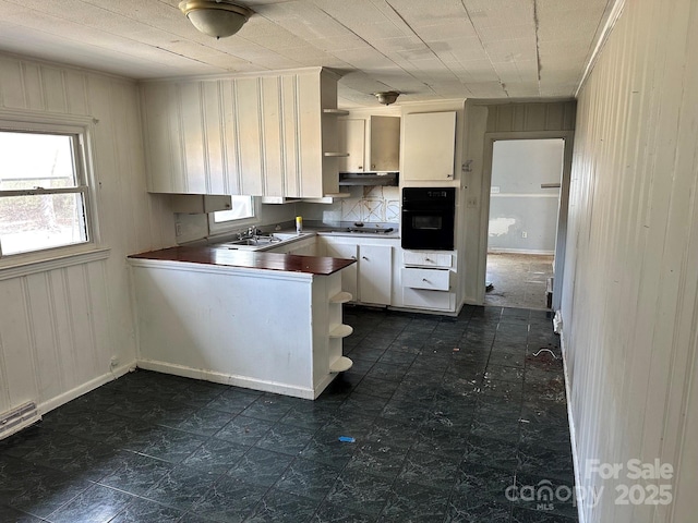 kitchen featuring a wealth of natural light, dark floors, white gas stovetop, and oven