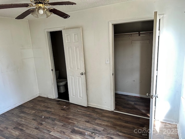 unfurnished bedroom featuring baseboards, a closet, dark wood-style floors, a textured ceiling, and a ceiling fan