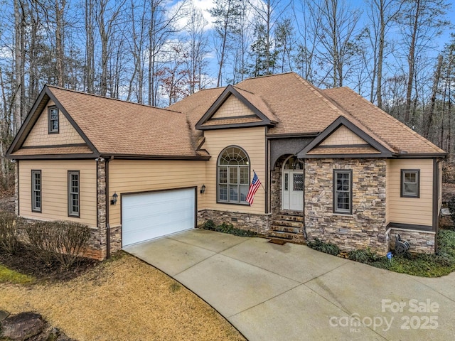 craftsman-style house featuring a garage, stone siding, concrete driveway, and a shingled roof