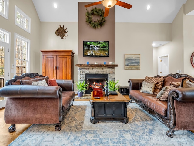 living room featuring ceiling fan, a stone fireplace, recessed lighting, wood finished floors, and high vaulted ceiling