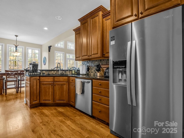 kitchen with brown cabinets, stainless steel appliances, and a sink