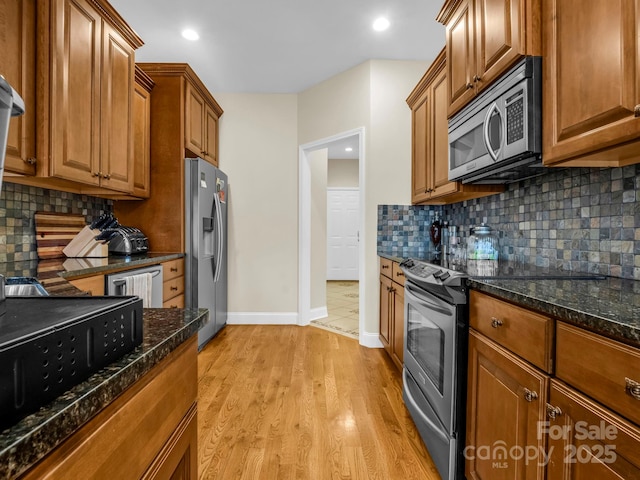 kitchen featuring decorative backsplash, appliances with stainless steel finishes, light wood-style flooring, and brown cabinetry