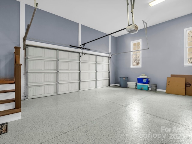 garage featuring a garage door opener and baseboards