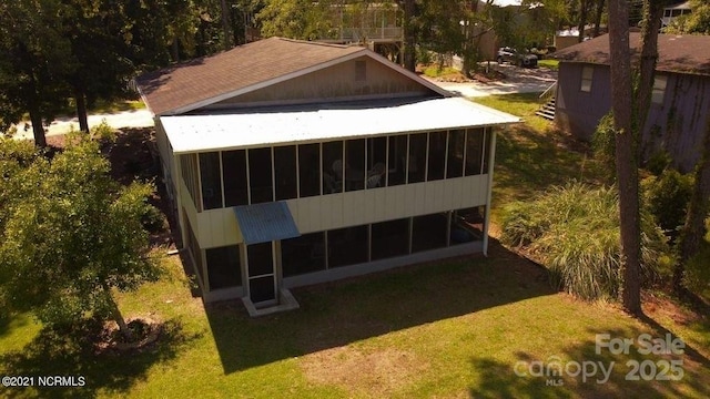 exterior space featuring a lawn and a sunroom