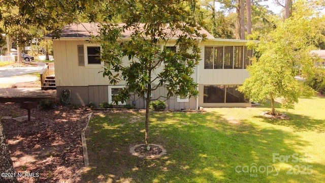 back of house with a yard and a sunroom