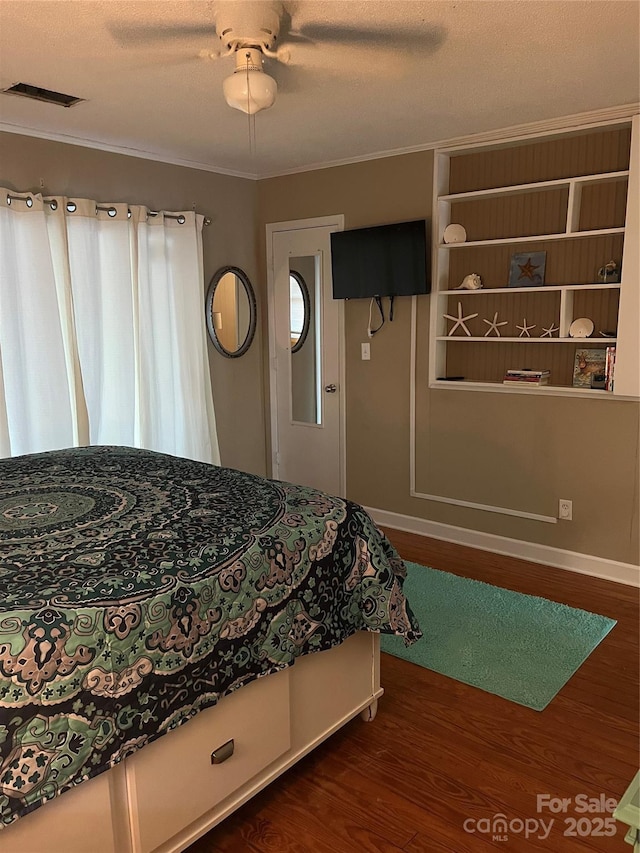 bedroom featuring dark wood finished floors, visible vents, crown molding, and ceiling fan