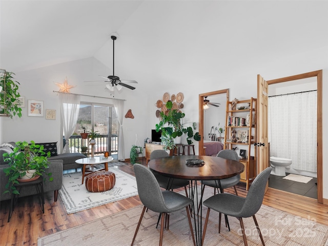 dining room featuring ceiling fan, high vaulted ceiling, and wood finished floors