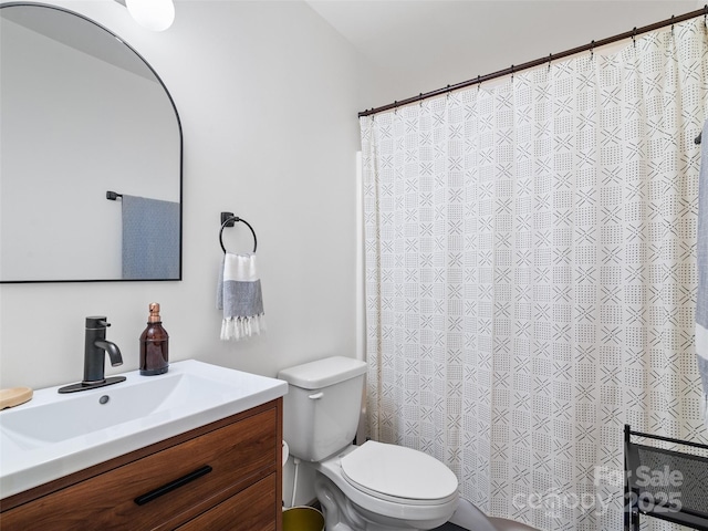 bathroom featuring a shower with shower curtain, toilet, and vanity