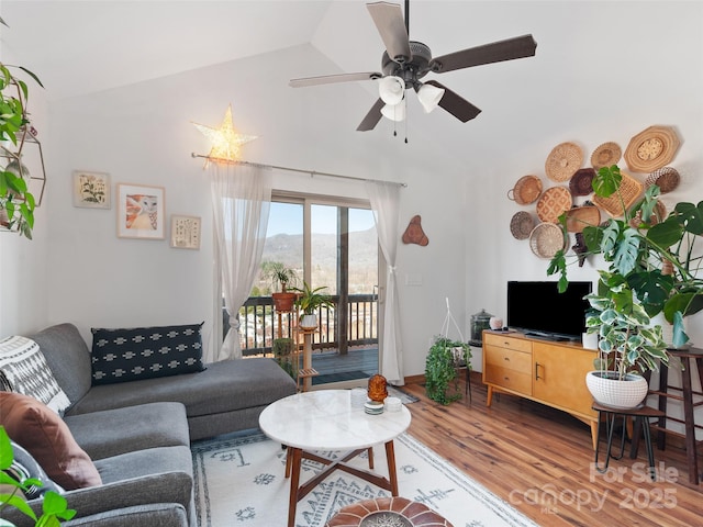 living area featuring a ceiling fan, lofted ceiling, and wood finished floors