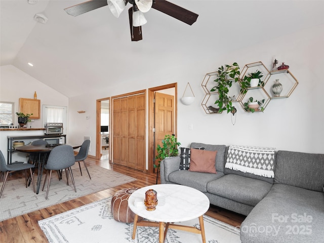 living room featuring lofted ceiling, a toaster, light wood-style floors, and ceiling fan