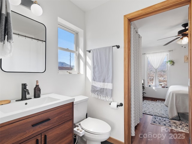 bathroom featuring a wealth of natural light, wood finished floors, toilet, and ensuite bath