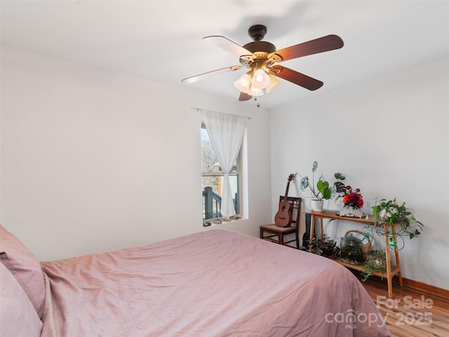 bedroom featuring baseboards, ceiling fan, and wood finished floors