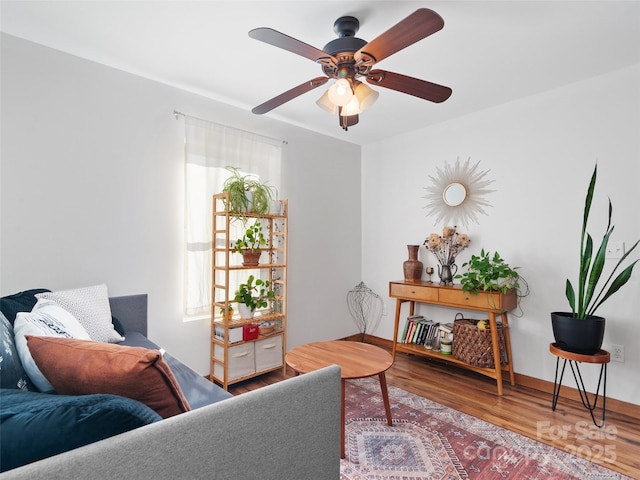 living room with baseboards, a ceiling fan, and wood finished floors