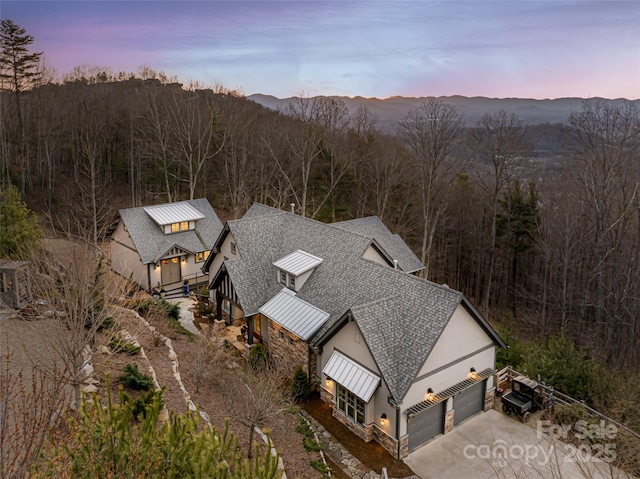 aerial view featuring a view of trees and a mountain view