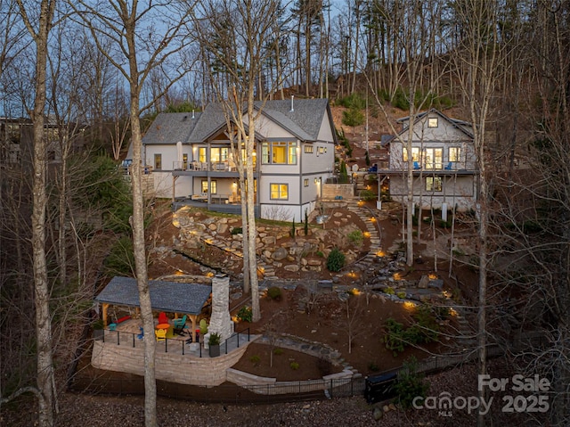 back of property with roof with shingles and a wooden deck