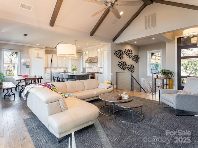 living room with beamed ceiling, wood finished floors, and visible vents