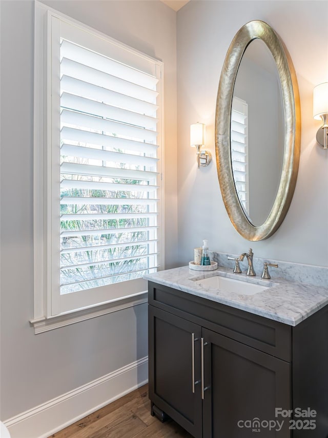 bathroom with vanity, baseboards, and wood finished floors