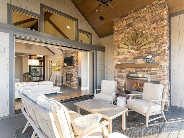 view of patio with visible vents, an outdoor stone fireplace, a deck, and a ceiling fan