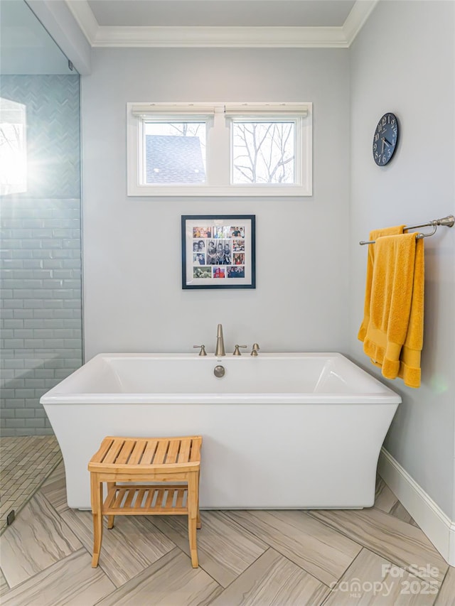 full bath featuring a freestanding bath, crown molding, and baseboards